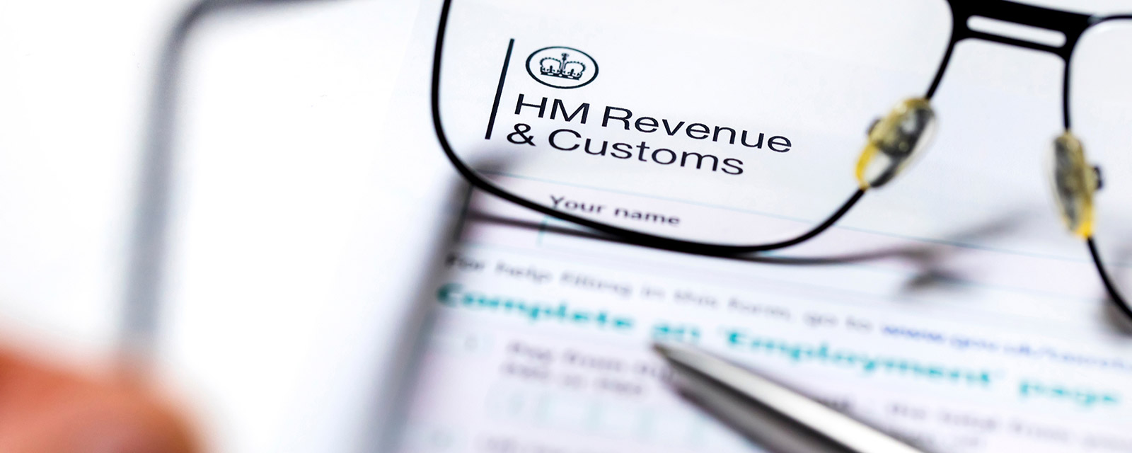 Someone holding glasses up to a HMRC letter.